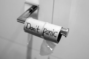 Beschriebene leere Toilettenpapierrolle mit den Worten 'Don't panic'